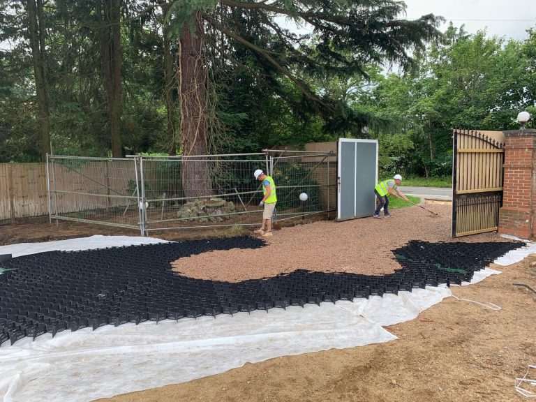 Image of tree with barrier around it for protection as Men work around it creating a driveway